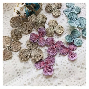 May include: Assortment of delicate, embroidered flower appliques in various colors, including silver, pink, and blue. The appliques are perfect for adding a touch of elegance to clothing, crafts, or home decor.