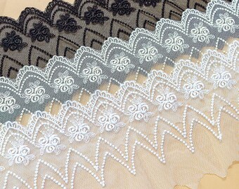 Peut inclure: Trois couches de dentelle blanche, grise et noire avec un bord festonné et une broderie florale.