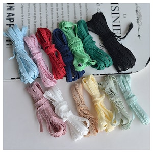 May include: Assortment of 12 colors of ruffled elastic trim. The trim is approximately 1/2 inch wide and is available in colors such as black, red, blue, green, light blue, pink, white, beige, and yellow.