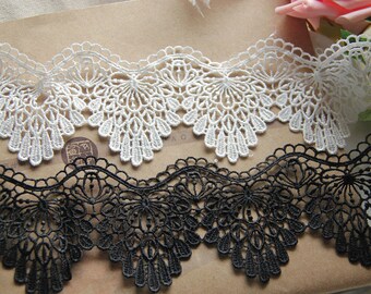 Peut inclure: Deux galons de dentelle, l'un blanc et l'autre noir. Les deux galons ont un bord festonné et un motif floral délicat.