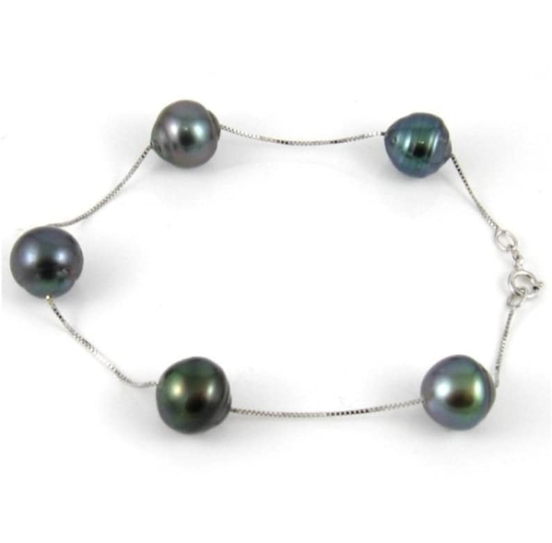 May include: A silver chain bracelet with four dark green pearls.