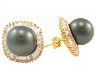 May include: A pair of gold earrings with a black pearl and a halo of clear cubic zirconia stones.