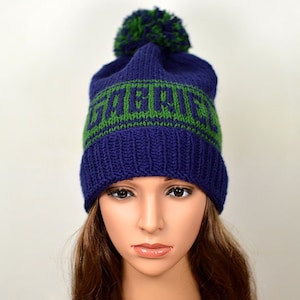 May include: A blue knitted beanie with a green pom pom and green lettering that says "Hufflepuff".