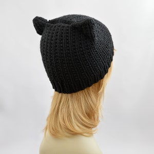 May include: Black knit beanie with cat ears. The beanie is made of a soft, warm material and is perfect for keeping your head and ears warm in the winter.