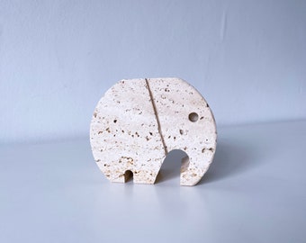 Könnte beinhalten: Eine weiße Steinelefanten-Skulptur mit einer rauen, strukturierten Oberfläche.