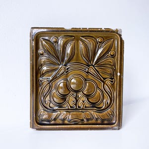 An Arts and Crafts / Art Nouveau Tile in Green Glaze