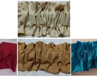 May include: Four different colors of fabric trim with a ruffled design. The colors are beige, red, brown, and teal.