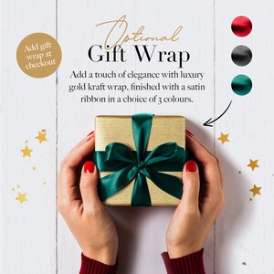 May include: A gold gift box with a green satin ribbon. The text "Optional Gift Wrap" is above the box. The text "Add a touch of elegance with luxury gold kraft wrap, finished with a satin ribbon in a choice of 3 colours." is below the box. The text "Add gift wrap at checkout" is in a circle in the upper left corner of the image.
