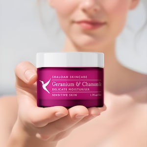 Peut inclure: Un pot rose de crème hydratante délicate à la géranium et à la camomille pour peaux sensibles de Shaloah Skincare. Le pot est de 1,7 fl oz / 50 ml.