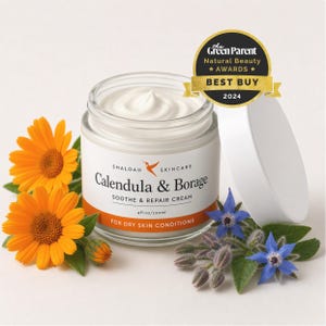 Peut inclure: Un pot en verre de crème apaisante et réparatrice Shaloah Skincare Calendula & Borage, 120ml, avec un couvercle blanc et le sceau Green Parent Natural Beauty Awards 2024 Best Buy. L'étiquette est entourée de fleurs orange et bleues.