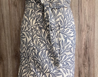 Half apron in blue and beige William Morris cotton fabric. Wide half apron with long straps and two pockets. Blue leaves.