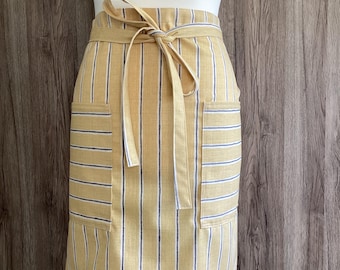 Yellow half apron with grey and white stripes. Wide half apron with long straps and two pockets.  Iliv Rowing Stripes Sand cotton fabric.