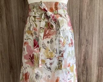 Half apron in Iliv Water Meadow Rosewood floral cotton fabric. Two pockets and long straps. Wide half apron. Red, green, mustard, grey.
