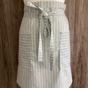 Wide half apron with long straps and two pockets. Striped duckegg and white cotton apron. Light blue and white stripes.