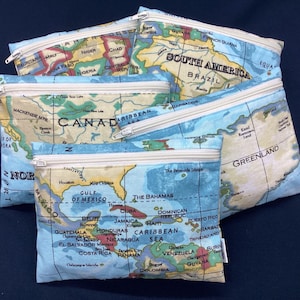 Può includere: Quattro pochette con cerniera con un design a mappa del mondo. Ogni pochette presenta un continente diverso: Nord America, Sud America, Africa e Groenlandia. Le pochette sono realizzate in un materiale morbido in tessuto e hanno una cerniera bianca.