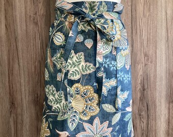 Wide half apron with long straps and two pockets in Chanterelle Mirage cotton fabric. Birds, leaves and flowers. Blue, green, yellow.