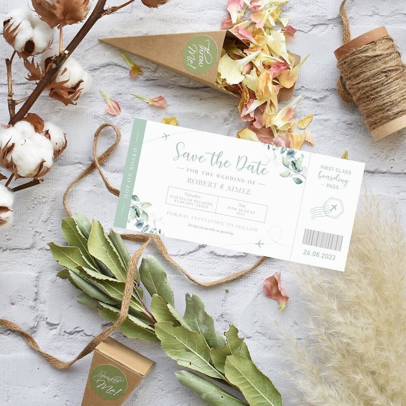 May include: Save the Date wedding invitation in the form of a boarding pass with a green floral design. The invitation says "Save the Date" for the wedding of Robert & Aimee. The date is 26 August 2023.