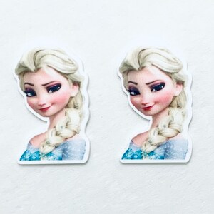 May include: Two printed images of Elsa from the movie Frozen. Elsa is wearing a blue and white dress with a braid in her hair. She has a light blue background.