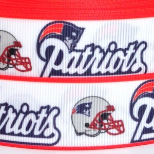Pode incluir: Fita branca e vermelha com um padr&atilde;o repetido de um capacete de futebol e a palavra "Patriots" em letras azuis e brancas.