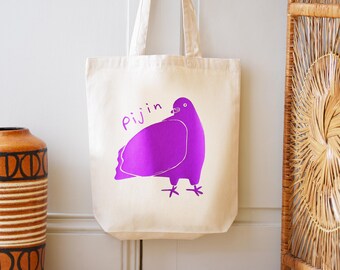 Puede incluir: Una bolsa de tela blanca con una ilustración de una paloma morada y la palabra "Pijin" impresa en ella.