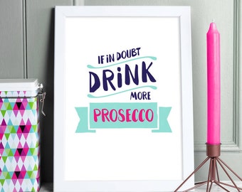 Op de afbeelding: Witte ingelijste print met de tekst "In twijfel drink meer prosecco" in blauwe en roze letters op een witte achtergrond.