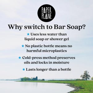 May include: A white background with blue text that reads "PAPER PLANE" in a stylized font. Below the text is a blue heading that reads "Why switch to Bar Soap?" with four bullet points listing the benefits of using bar soap. The bullet points are: "Uses less water than liquid soap or shower gel", "No plastic bottle means no harmful microplastics", "Cold-press method preserves oils and locks in moisture", and "Lasts longer than a bottle". The image is set against a background of a lake and green grass.