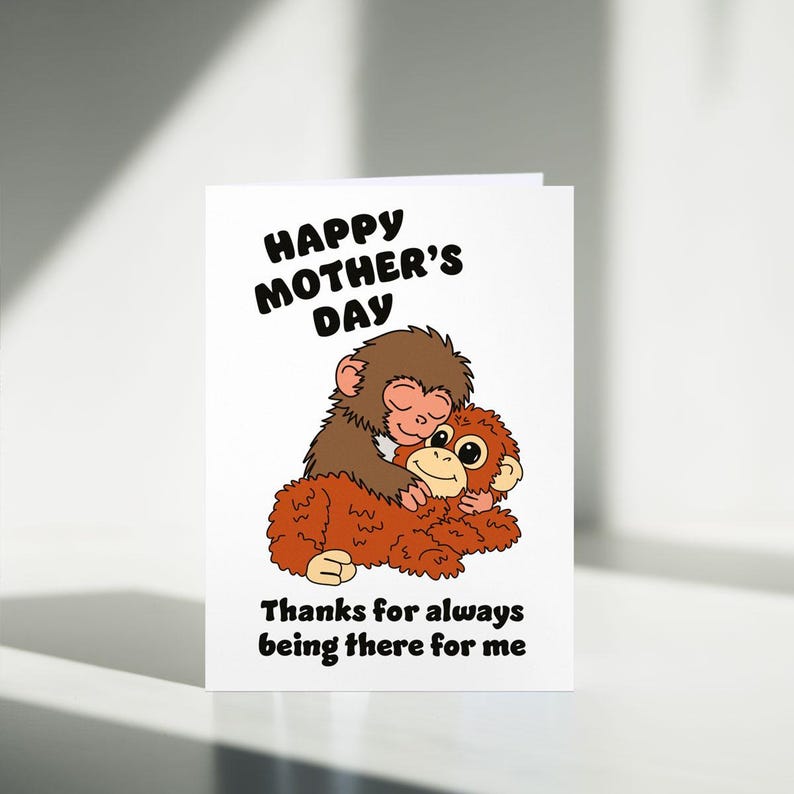 May include: A white Mother's Day greeting card featuring a cartoon illustration of two monkeys hugging. The text "Happy Mother's Day" is at the top, with "Thanks for always being there for me" at the bottom.