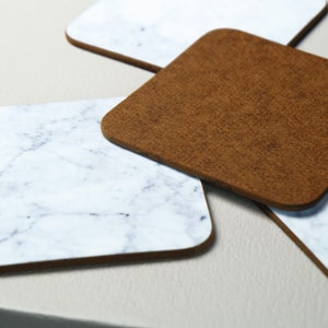 May include: Four coasters, two are brown and two are white with a marble pattern.