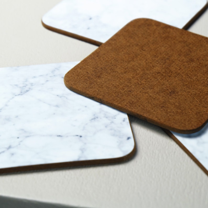May include: Four coasters, two are brown and two are white with a marble pattern.