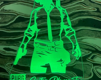 May include: Green illuminated acrylic lamp featuring a silhouette of a PUBG player wearing a helmet and holding a gun. The lamp base is black and the text "PUBG BATTLEGROUNDS Custom Player Tag" is visible at the bottom.