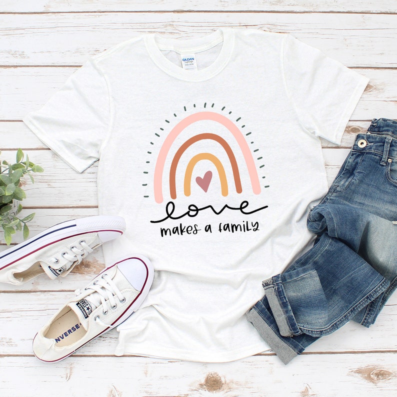 May include: White t-shirt with a rainbow design and the text "love makes a family".