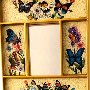May include: A vintage yellow framed tray with a central mirror and four decorative panels. Each panel features colorful butterfly and floral designs. The butterflies have intricate wing patterns in shades of blue, orange, and purple.
