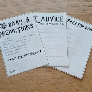 Puede incluir: Tres tarjetas de juego de baby shower imprimibles con temática de Harry Potter. Las tarjetas son blancas con texto y gráficos negros. La primera tarjeta se titula "Predicciones para el bebé" y tiene una lista de características del bebé para adivinar. La segunda tarjeta se titula "Consejos para los futuros padres" y tiene líneas en blanco para que los invitados escriban consejos. La tercera tarjeta se titula "Deseos para el bebé" y tiene líneas en blanco para que los invitados escriban deseos.