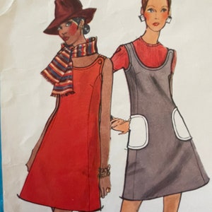 Peut inclure: Deux femmes portant des robes vintage des années 1960. La femme de gauche porte une robe rouge avec une écharpe rayée et un chapeau marron. La femme de droite porte une robe grise avec des poches blanches et des bottes rouges.