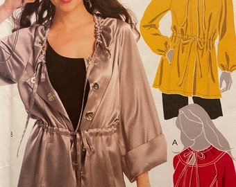 May include: A sewing pattern for a jacket with a drawstring waist and a ruffled collar. The pattern includes three different styles: a hooded jacket, a jacket with a tie at the neck, and a jacket with a tie at the waist.
