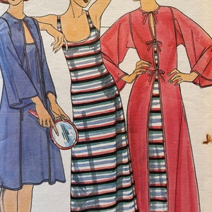 May include: Three women's dresses in different styles. The dress on the left is a blue robe with a tie at the neck. The dress in the centre is a striped maxi dress with a scoop neck. The dress on the right is a pink robe with a tie at the neck and long sleeves.