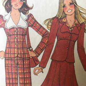 May include: Two women's fashion illustration featuring a plaid pantsuit and a red skirt suit. The pantsuit has a white collar and a plaid pattern in red, yellow, and black. The skirt suit has a red collar with a floral pattern and a solid red skirt.