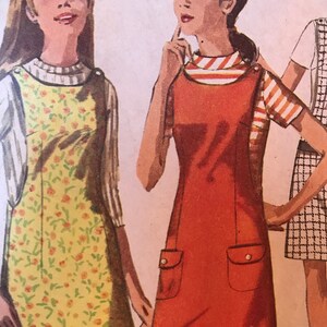 May include: Two women wearing different styles of dresses. The woman on the left is wearing a yellow dress with a floral pattern. The woman on the right is wearing a red dress with two pockets.