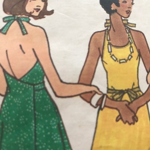 Puede incluir: Dos mujeres con vestidos de tirantes. La mujer de la izquierda lleva un vestido verde con lunares blancos. La mujer de la derecha lleva un vestido amarillo con un cinturón marrón y un collar dorado.