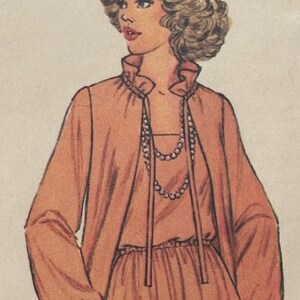 Puede incluir: Ilustración de una mujer con un vestido color melocotón y una chaqueta a juego. El vestido tiene un cuello con volantes y un collar de cuentas. La chaqueta está abierta por delante y las mangas están recogidas en las muñecas. La mujer tiene el pelo rubio.