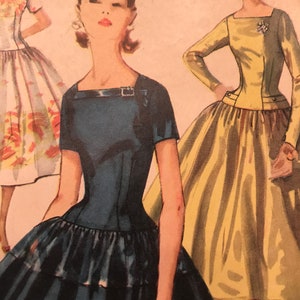 May include: Three women wearing vintage dresses. The woman in the center is wearing a dark blue dress with a fitted bodice and a full skirt. The woman on the left is wearing a white dress with a floral pattern. The woman on the right is wearing a yellow dress with a fitted bodice and a full skirt.