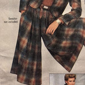 Könnte beinhalten: Ein Vintage-Anzug mit blauem, grünem und rotem Karomuster. Der Anzug besteht aus einer kurzen Jacke, einer weit geschnittenen Culotte und einem passenden Gürtel. Das Bild enthält auch den Text "Sweater not included" und "GO EVERY WHERE".