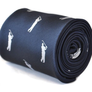 May include: A navy blue silk tie with a white golfer silhouette pattern.