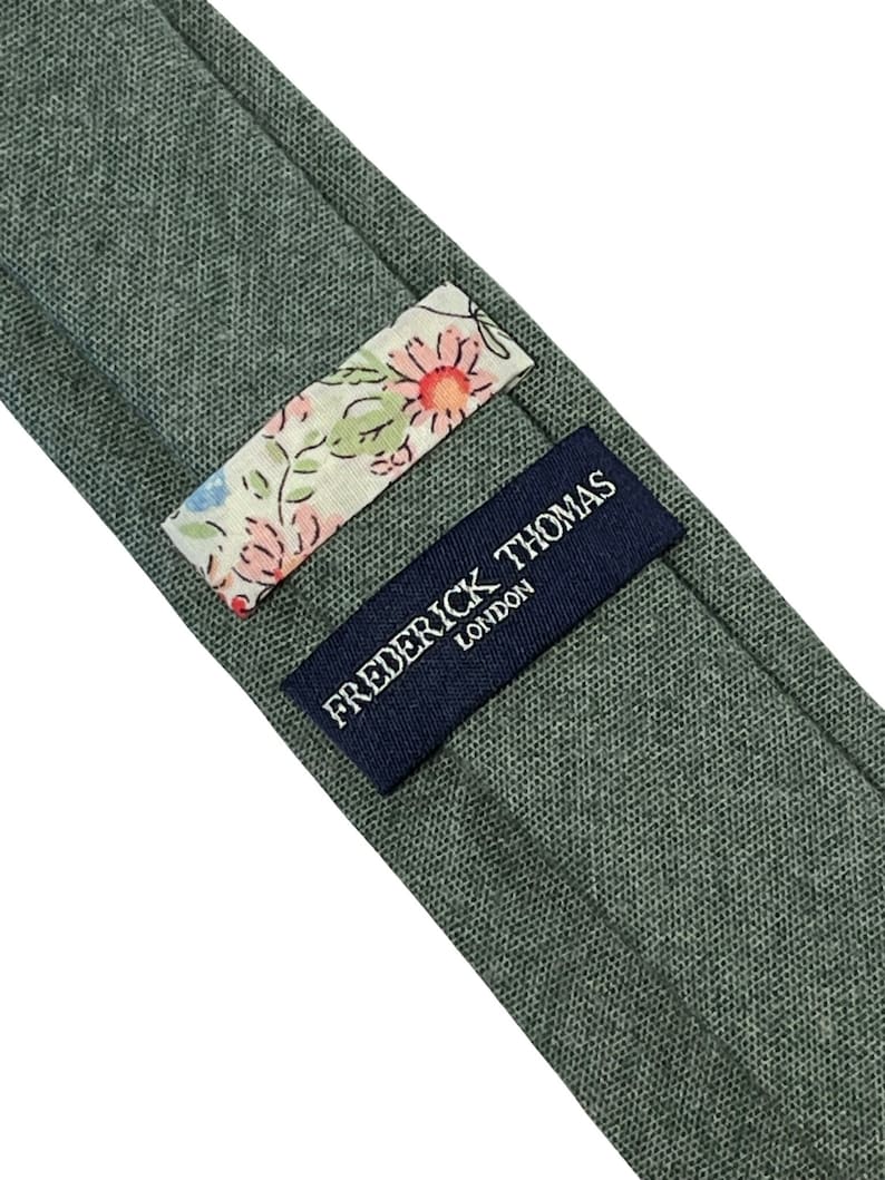 May include: A green linen tie with a floral patterned label and a navy blue label that reads "Frederick Thomas London".