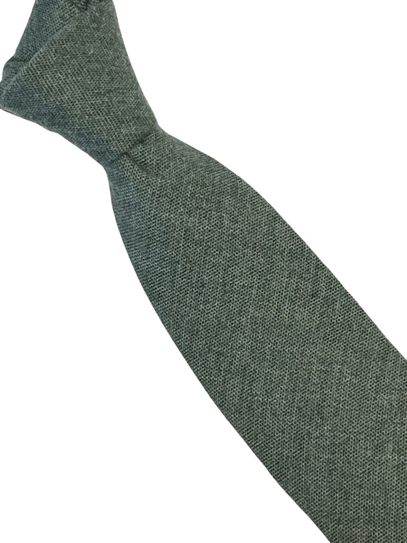 May include: A dark green linen tie. The tie is made of a textured fabric and has a narrow width.