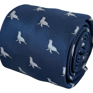 Puede incluir: Una corbata enrollada de color azul marino profundo con un patrón repetitivo de pequeños leones marinos de color gris claro. La tela tiene una textura visible de tejido de sarga diagonal en toda la superficie y está enrollada en forma cilíndrica.