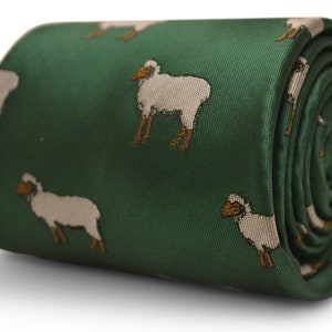 Puede incluir: Corbata verde enrollada con un patrón repetido de ovejas blancas con patas y caras marrones. La corbata está hecha de un material liso, posiblemente seda o satén, y está enrollada, mostrando la continuidad del patrón.
