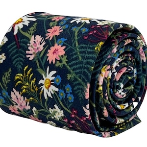 Op de afbeelding: Een donkerblauwe stropdas met een bloemenpatroon met roze, witte en gele bloemen op een donkergroene achtergrond.