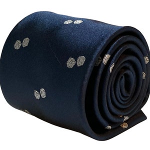 May include: A dark blue silk tie with a white polka dot pattern. The tie is rolled up and ready to be worn.