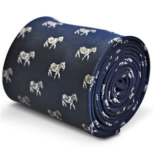 May include: A navy blue silk tie with a white zebra print pattern. The tie is rolled up and ready to be worn.